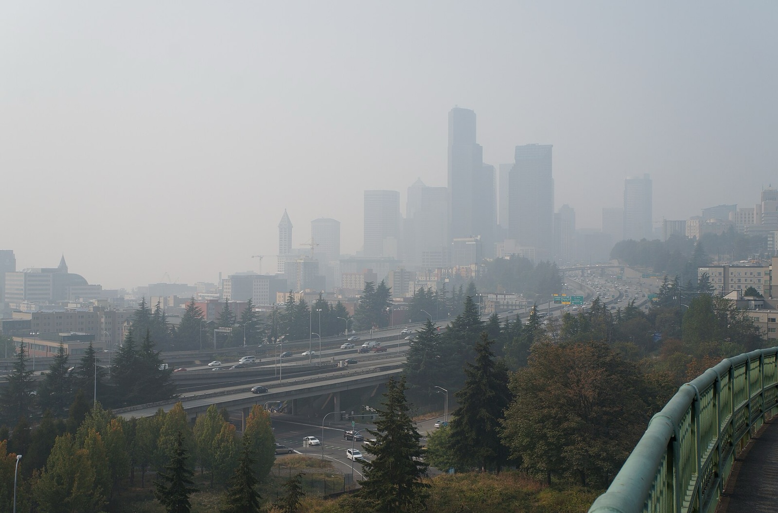 Downtown Seattle skyline nearly erased by dense wildfire smoke, with traffic moving on Interstate 5 in the foreground