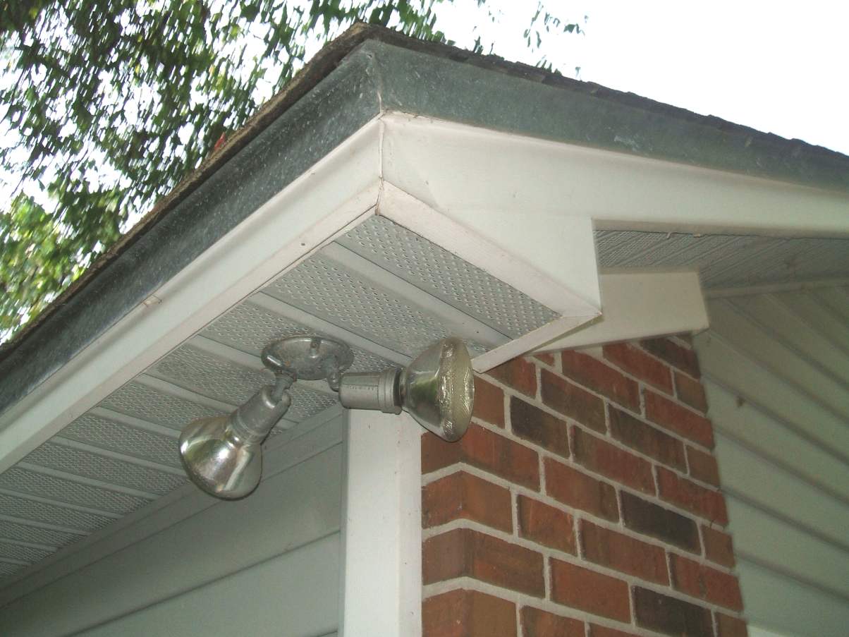 The corner of a house roofline showing a vented vinyl soffit