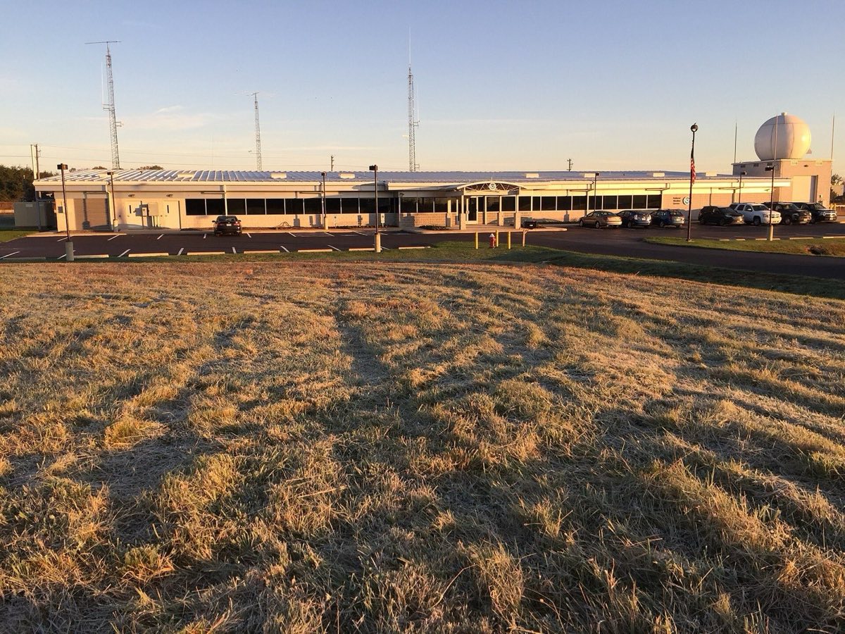 The National Weather Service Baltimore and Washington forecast office in Sterling, Virginia, with its radar dome, behind frosted grass