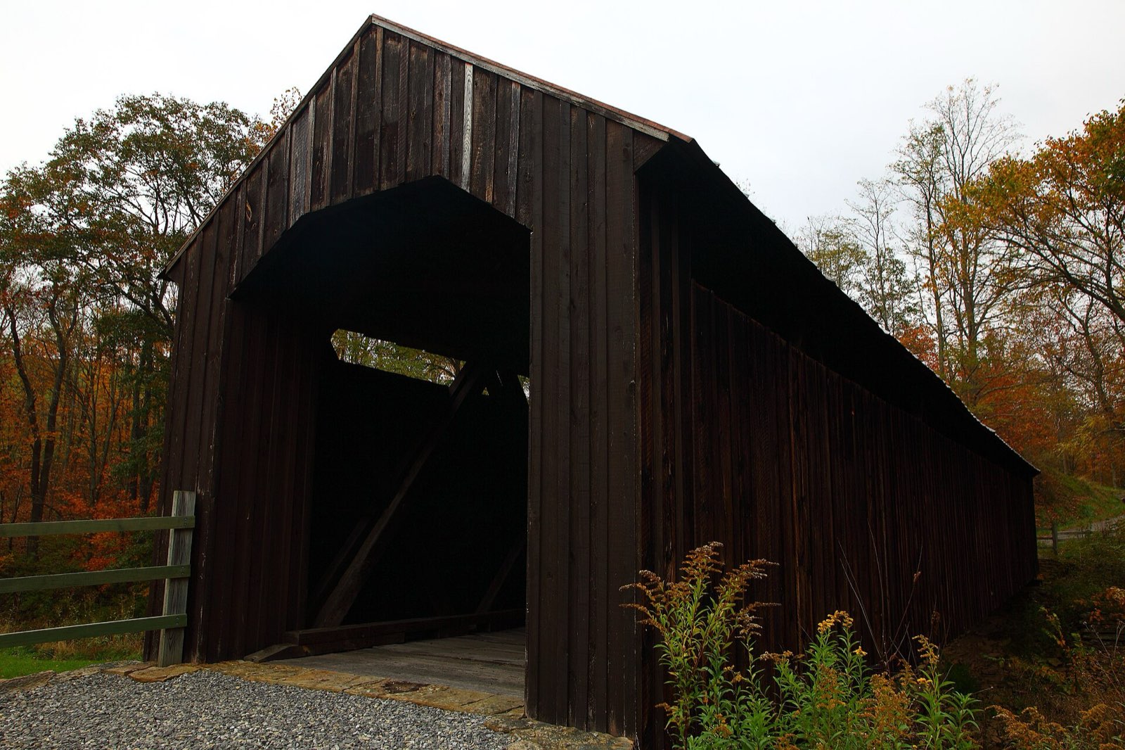 Covered bridge framed by peak fall foliage