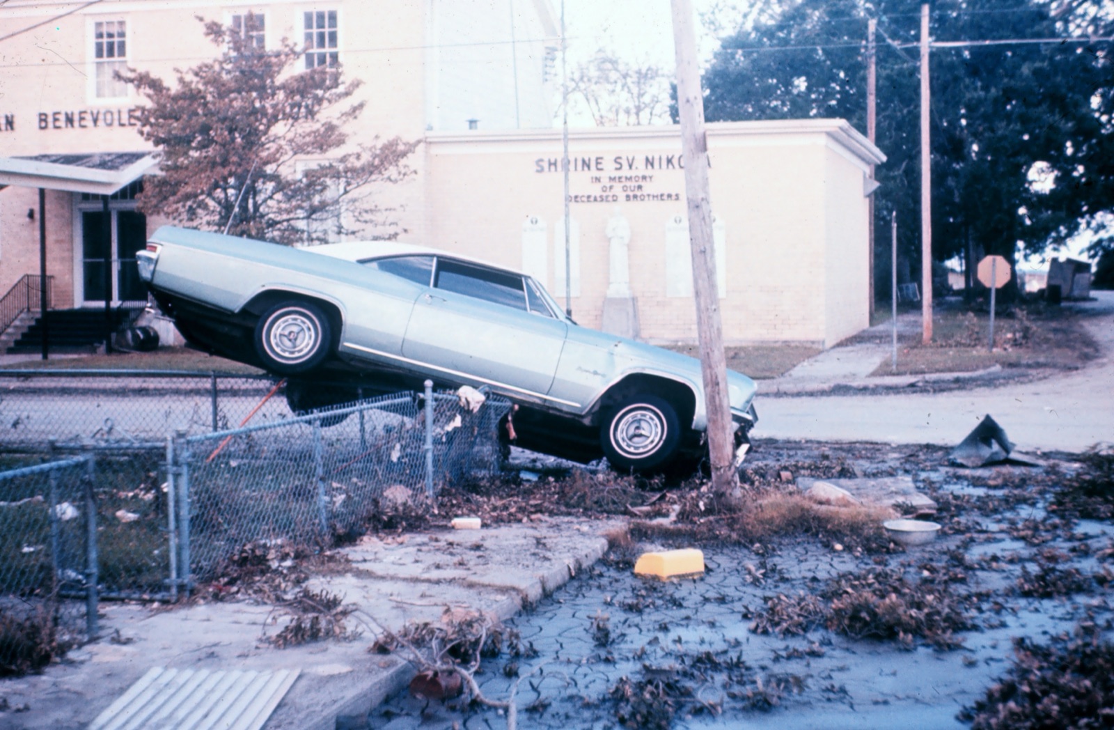 A car left tipped onto a chain link fence by Hurricane Camille storm surge in Biloxi, Mississippi