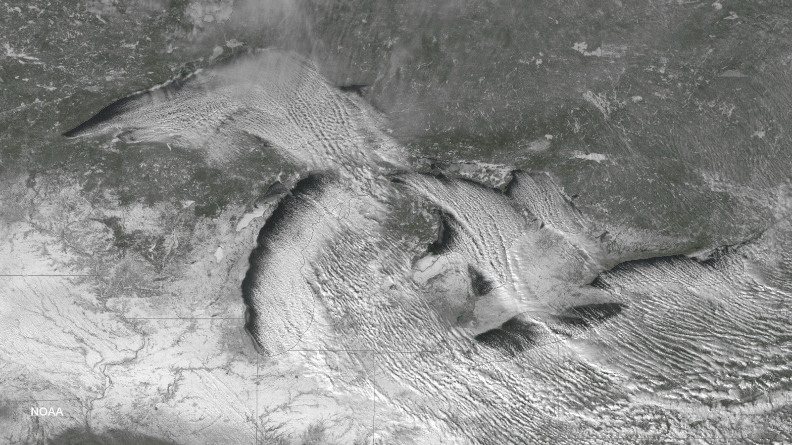 Satellite view of parallel lake effect snow bands streaming southeast off all five Great Lakes