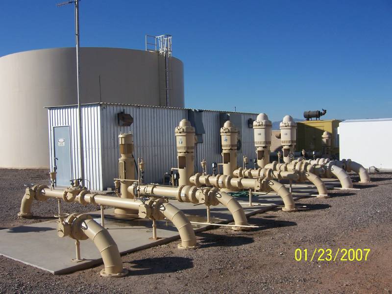 A row of groundwater well pumps and a storage tank at a small water facility, in an EPA photograph