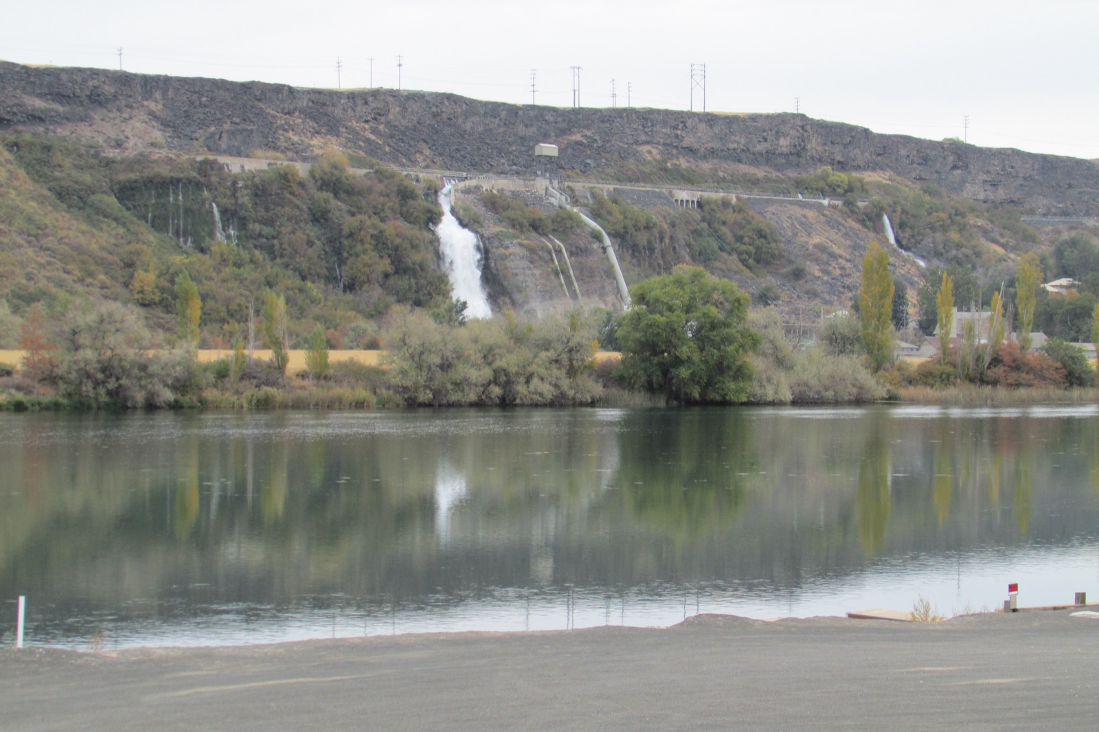 Water pouring in white falls from the basalt canyon wall above the Snake River in Idaho