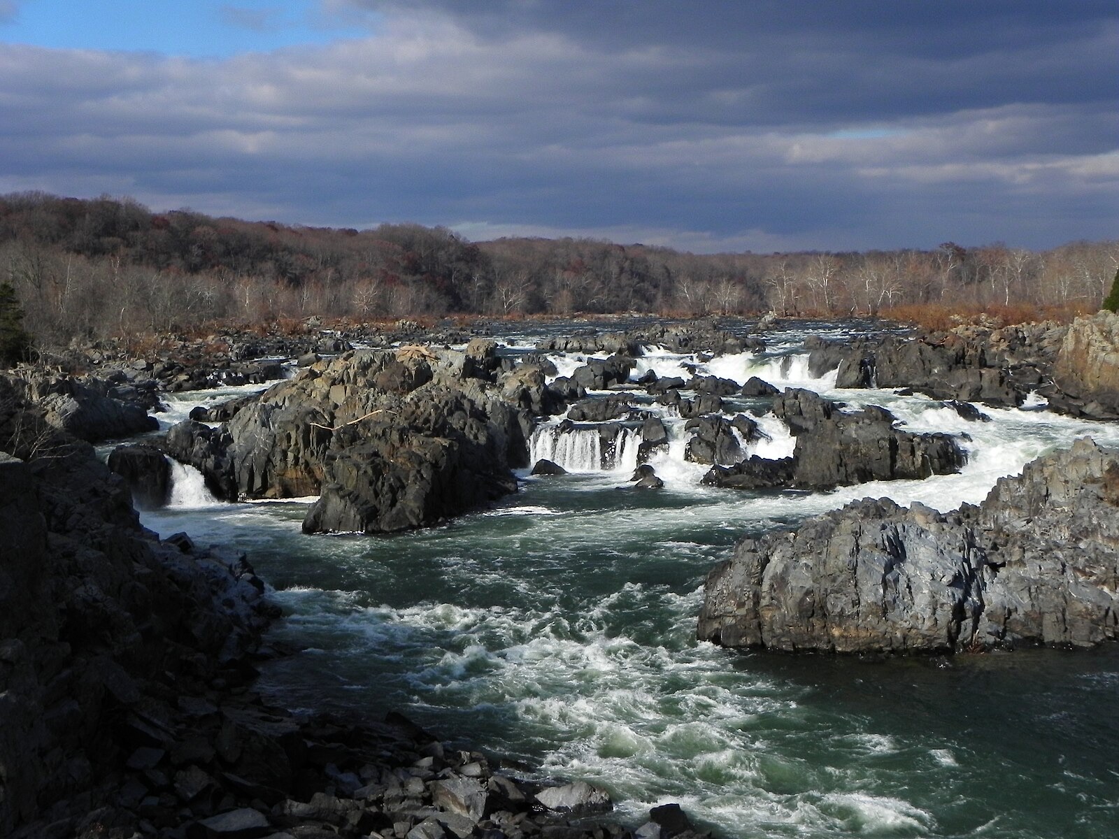 Great Falls of the Potomac in November, whitewater threading through dark rock under a stormy sky