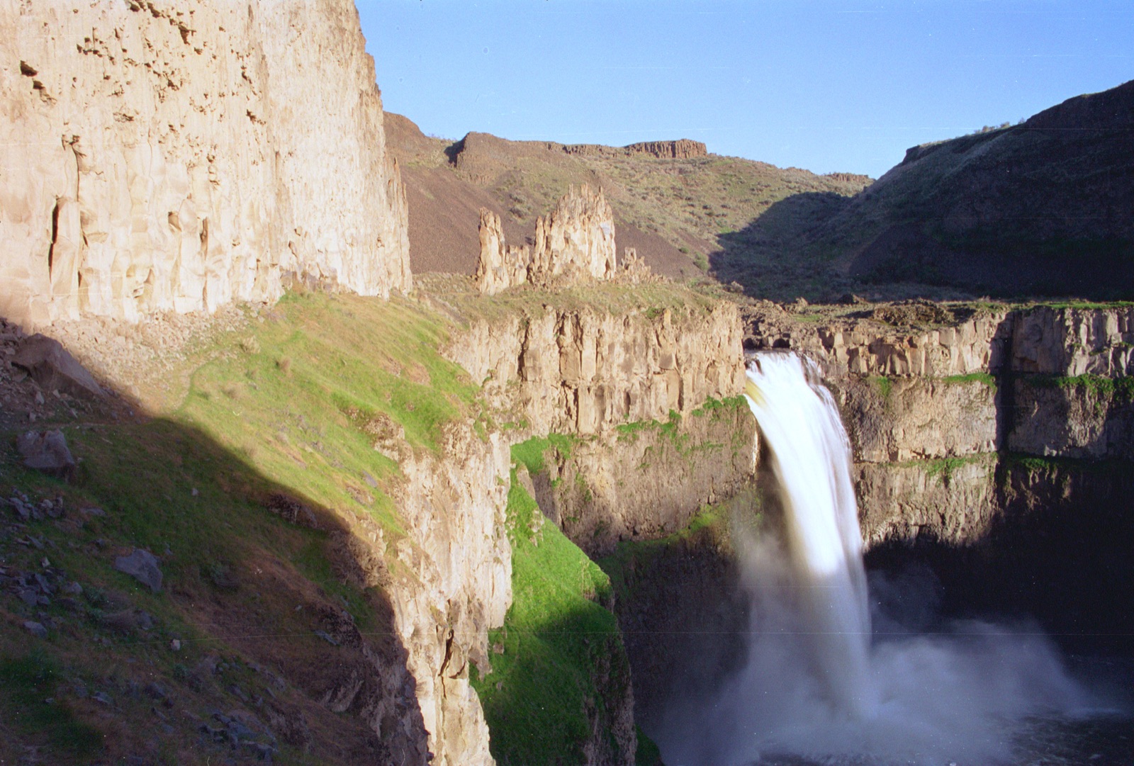 Palouse Falls pouring a wide white column into a basalt canyon in April