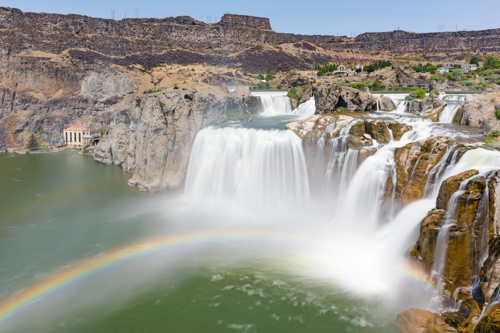 Shoshone Falls thundering at full width over the Snake River canyon rim with a rainbow in the mist