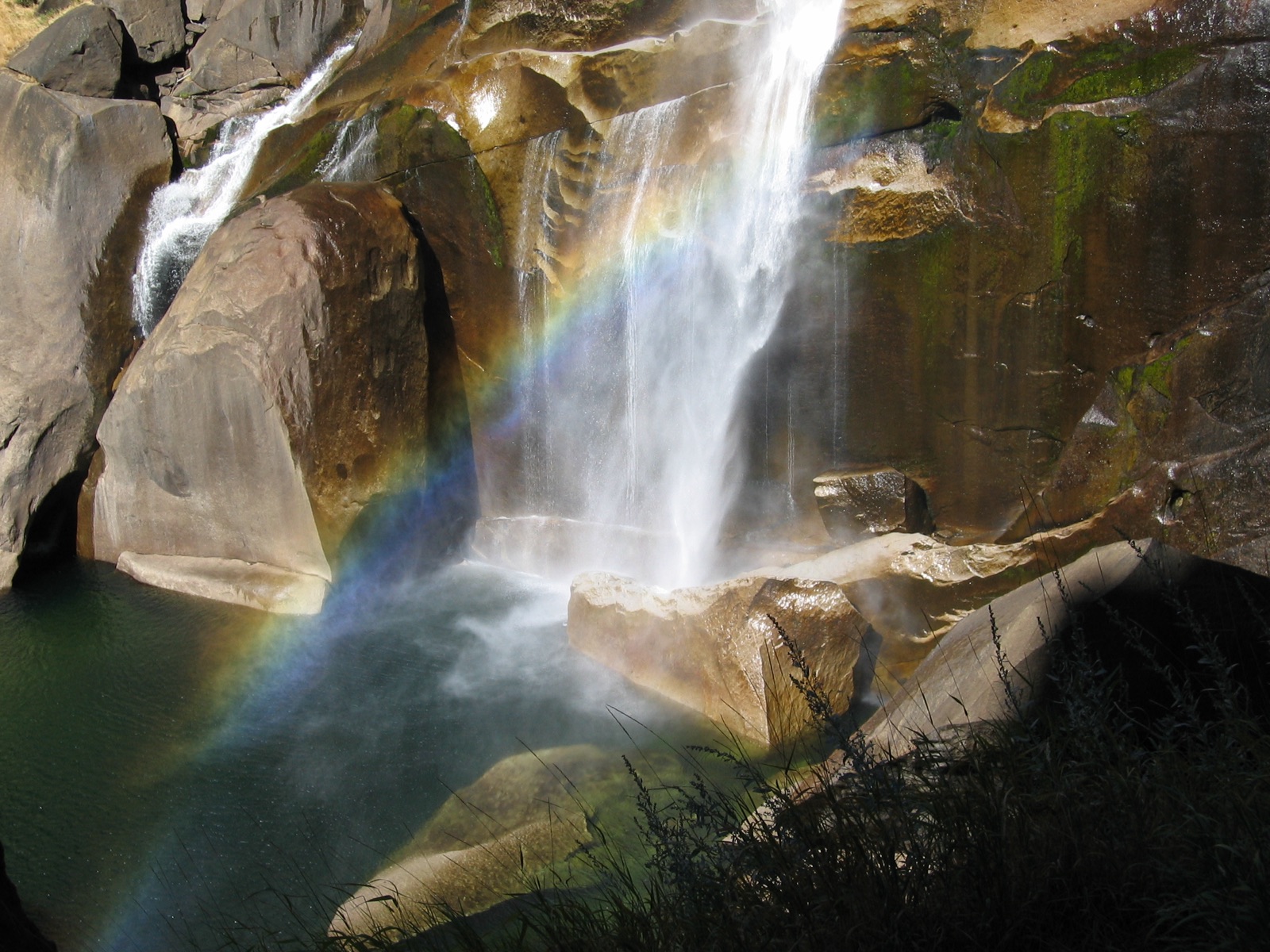 Clear mountain water pouring through a carved rock gorge