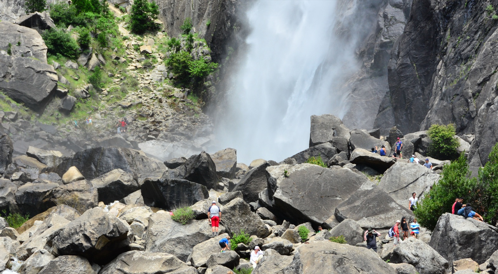 Lower Yosemite Fall in heavy spring flow with visitors on the boulder field below