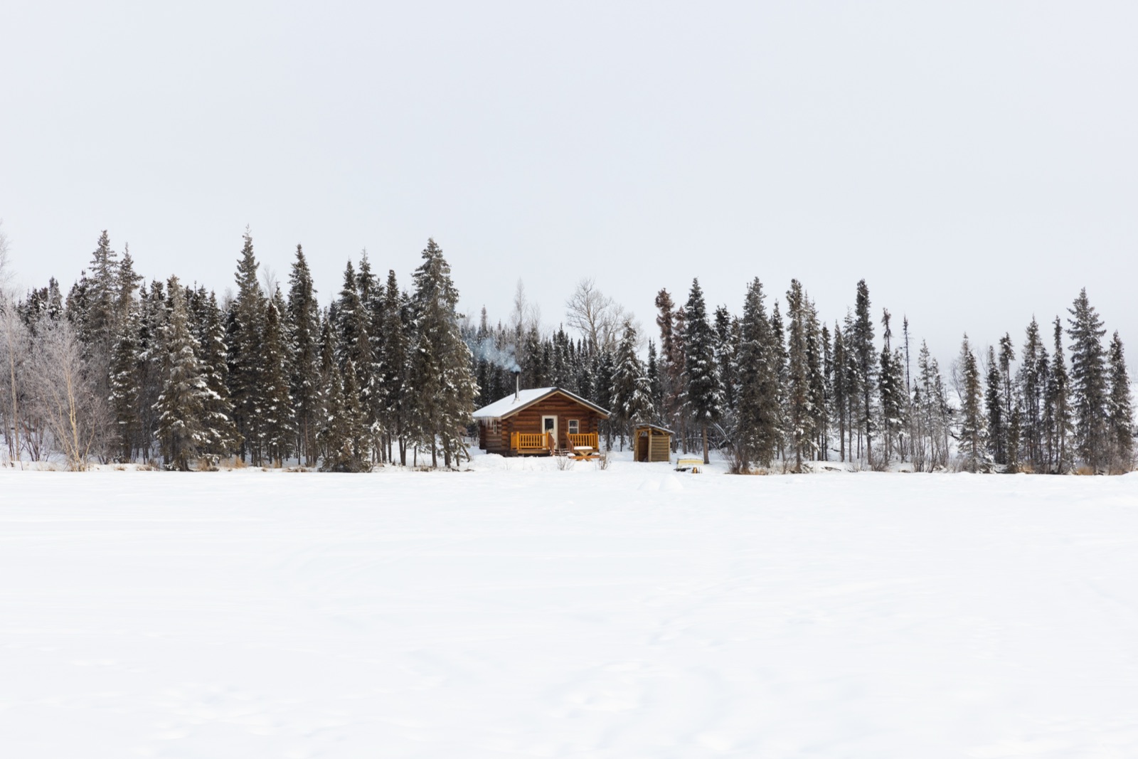 Snow-covered cabin in a winter forest