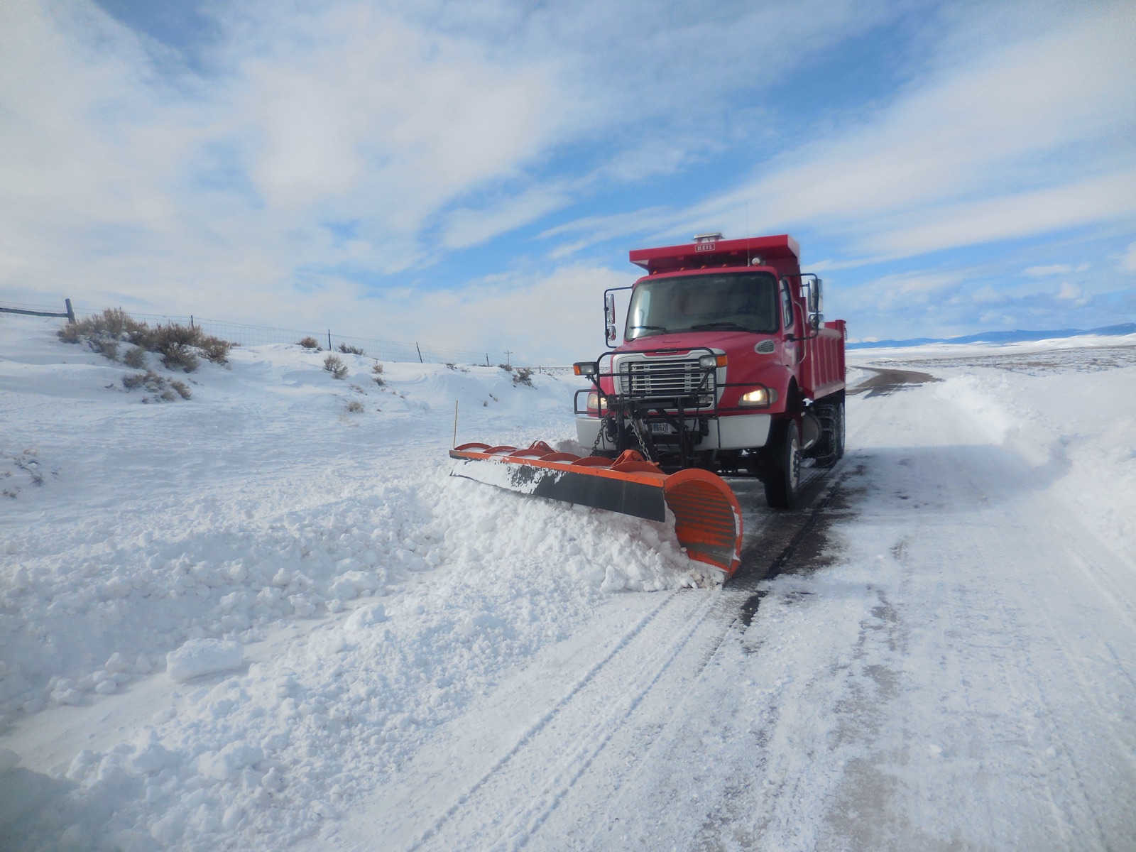 Snow plow clearing a mountain highway in deep snow