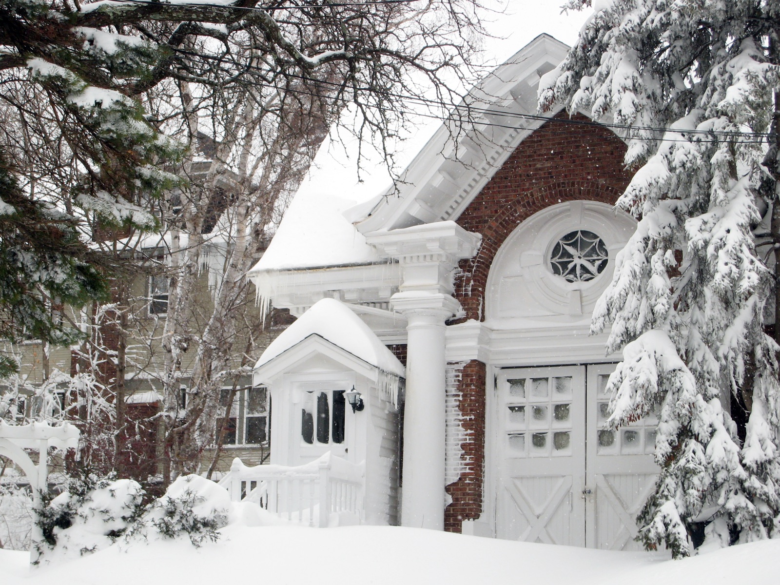 House buried in deep snow with icicles hanging from the gutters
